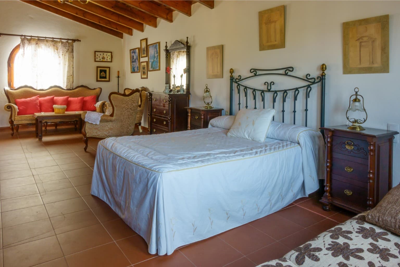 Bright master suite with a double bed and private lounge.