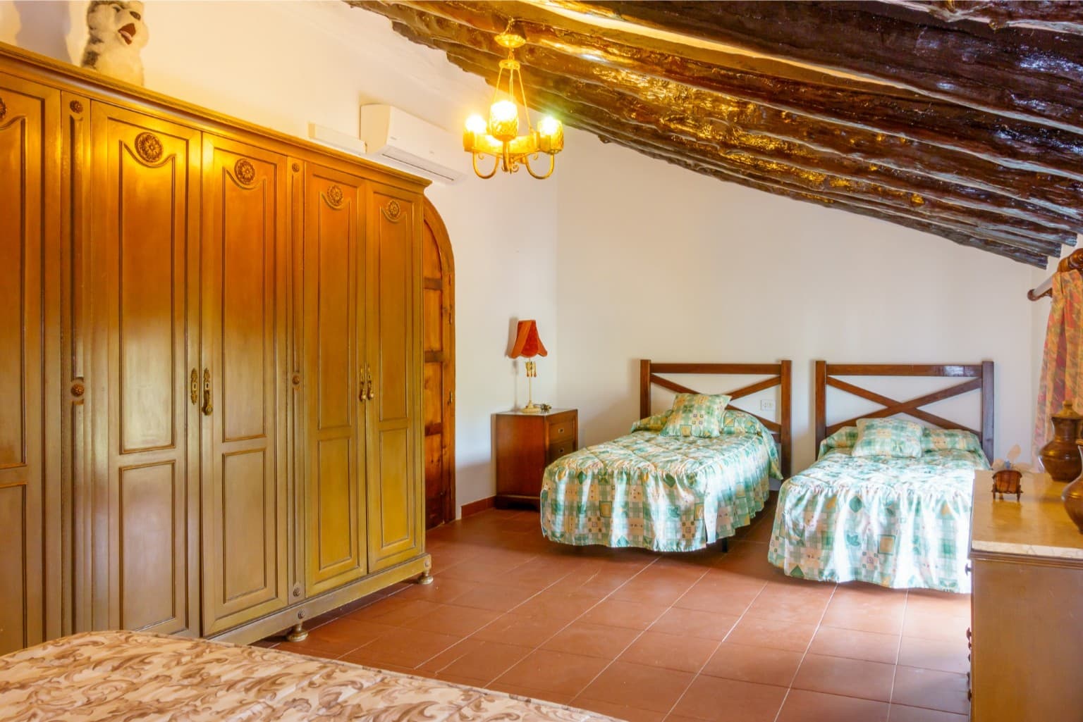Cozy twin bedroom featuring authentic massive wooden beams.