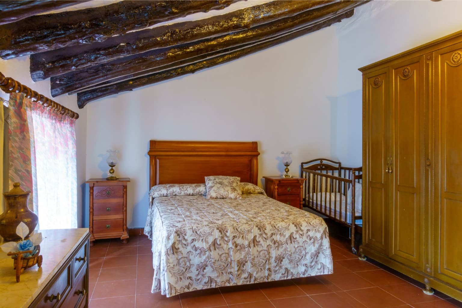 Inviting bedroom with sloped ceilings showcasing rustic character.