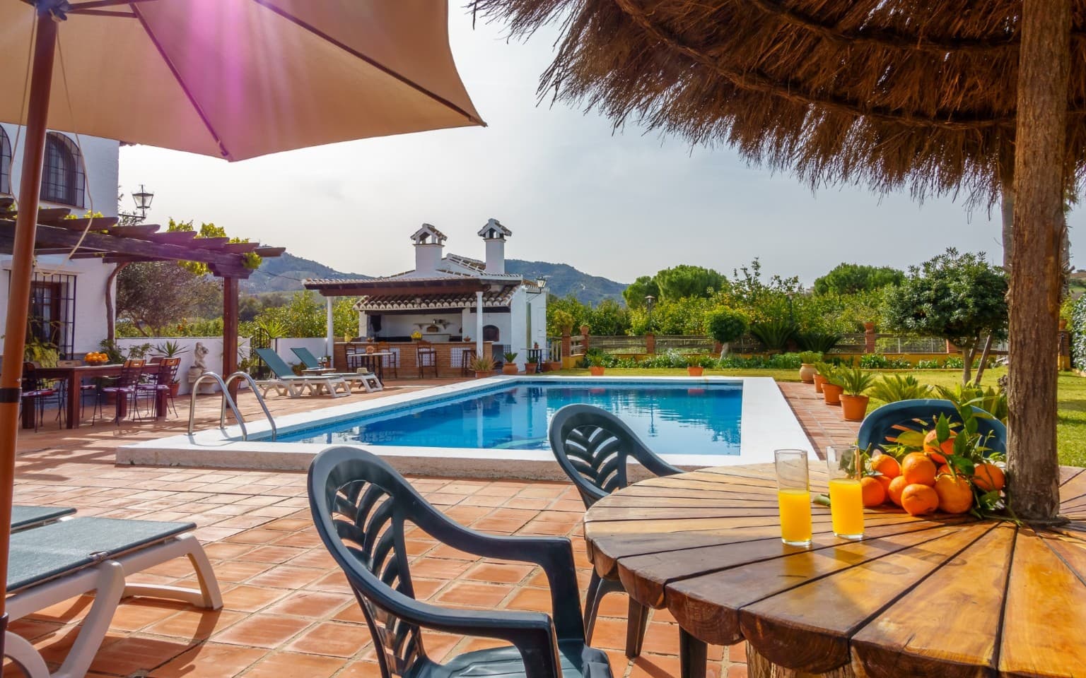 Shaded seating area under a rustic thatched umbrella.