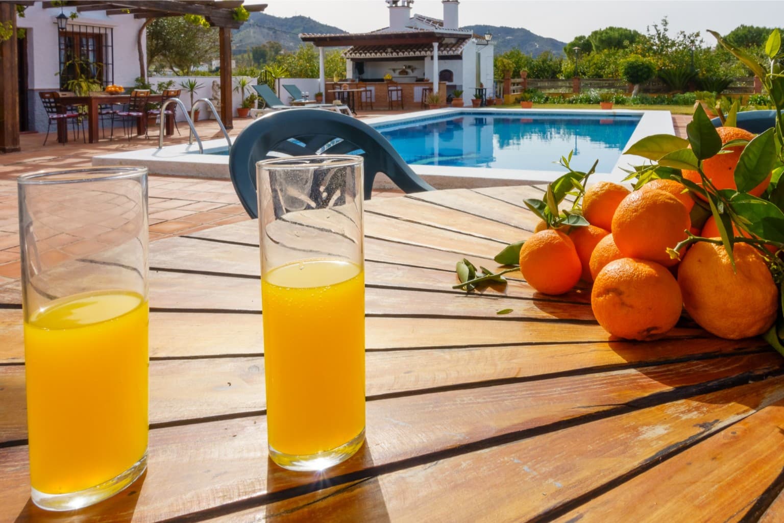 Freshly squeezed orange juice with the sparkling pool in the background.