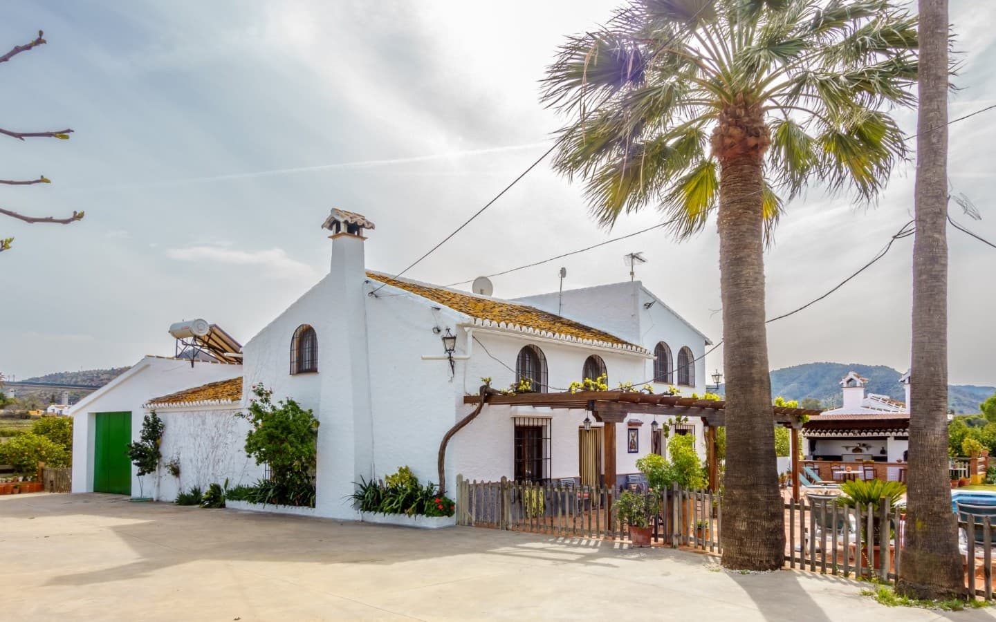 Secure parking area within the property surrounded by fruit trees.