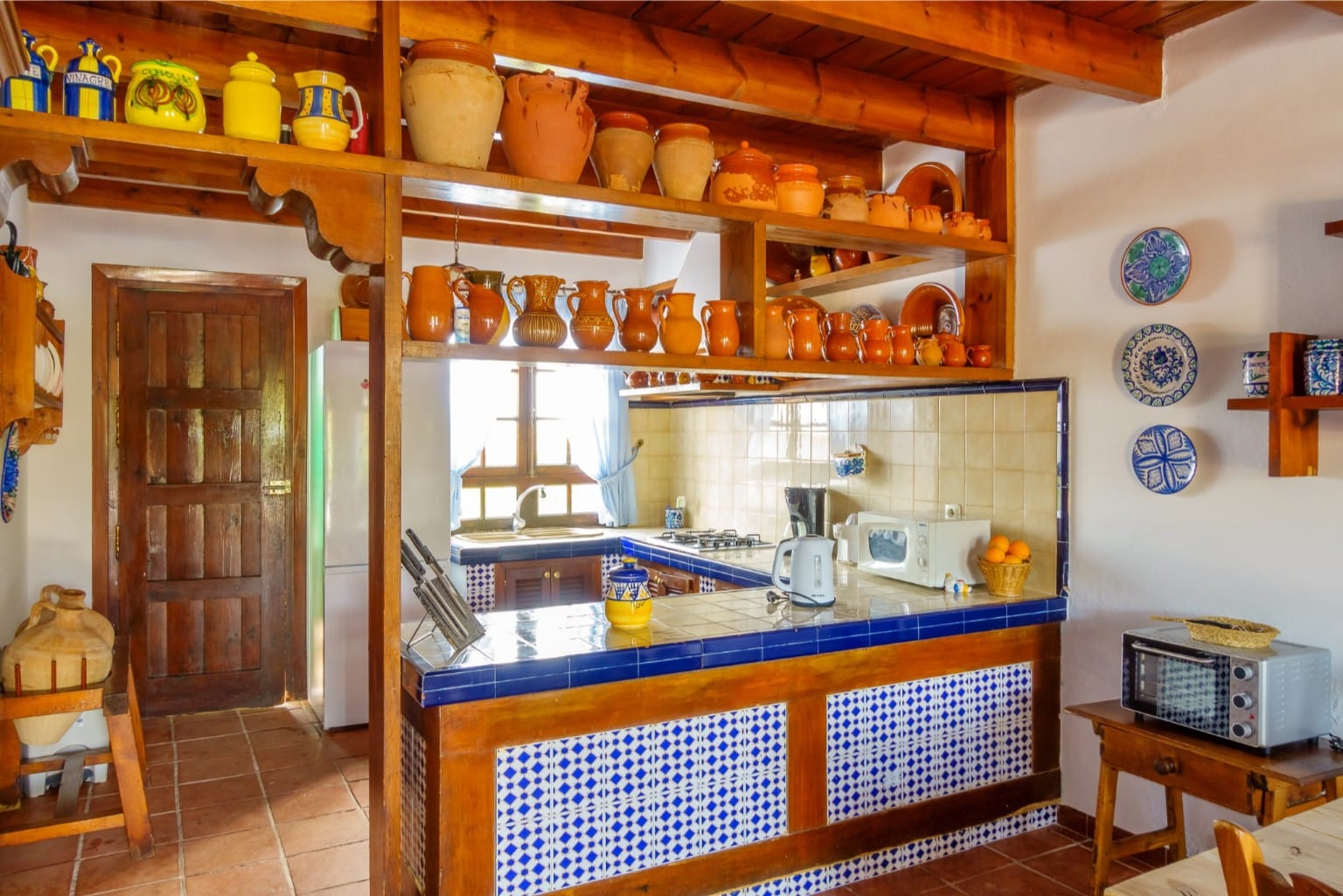 Spacious kitchen with blue-tiled island and modern appliances.